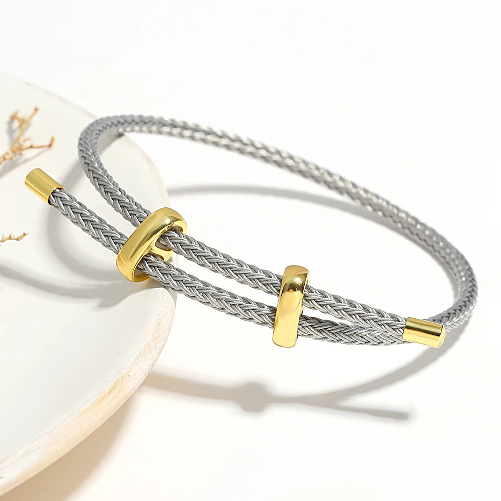 Silver braided bracelet with gold accents on a white surface