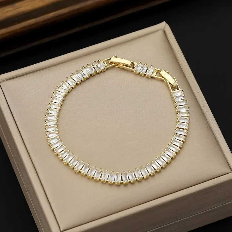 Gold bracelet with clear stones on a beige box
