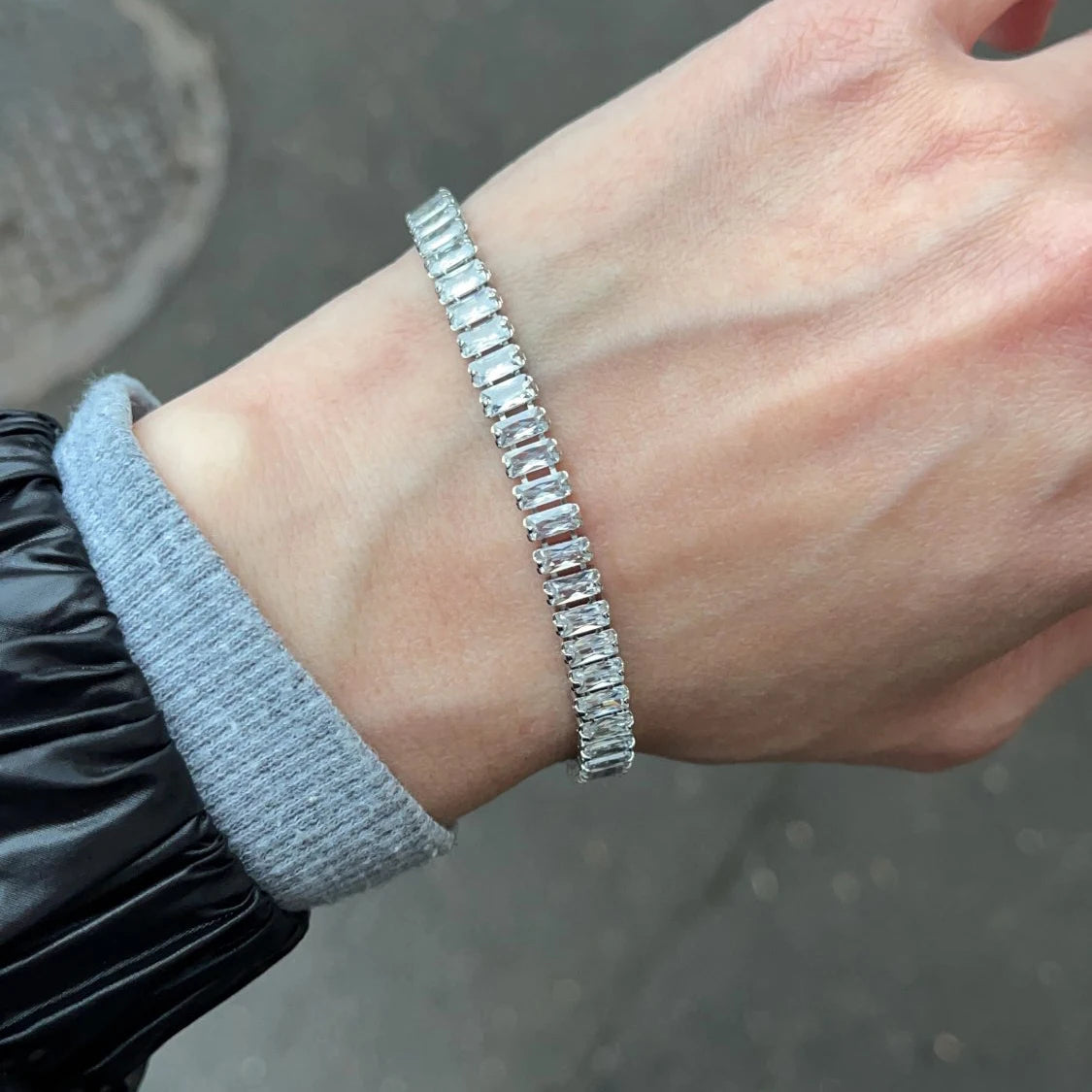 Silver bracelet on a wrist with a blurred background