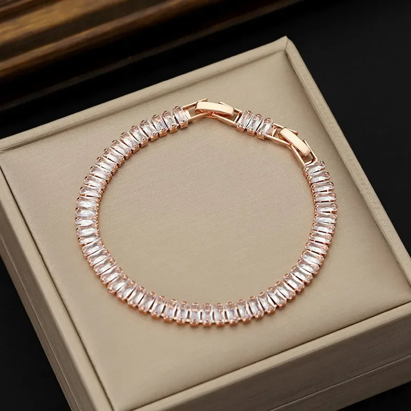 Rose gold bracelet with clear stones on a beige jewelry box