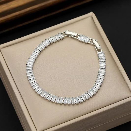 Silver bracelet with clear stones on a beige jewelry box