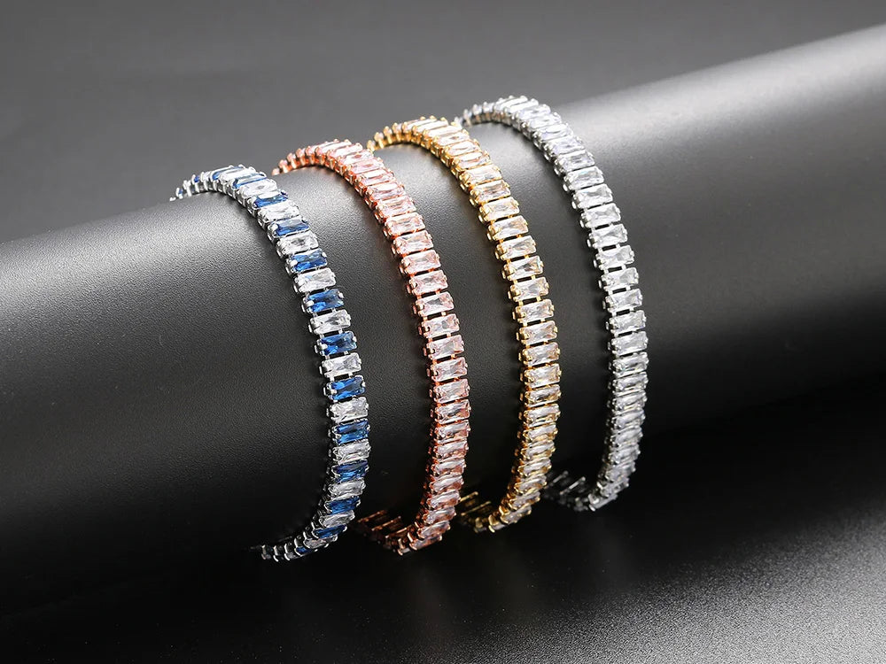 Three beaded bracelets in silver, rose gold, and blue on a dark surface