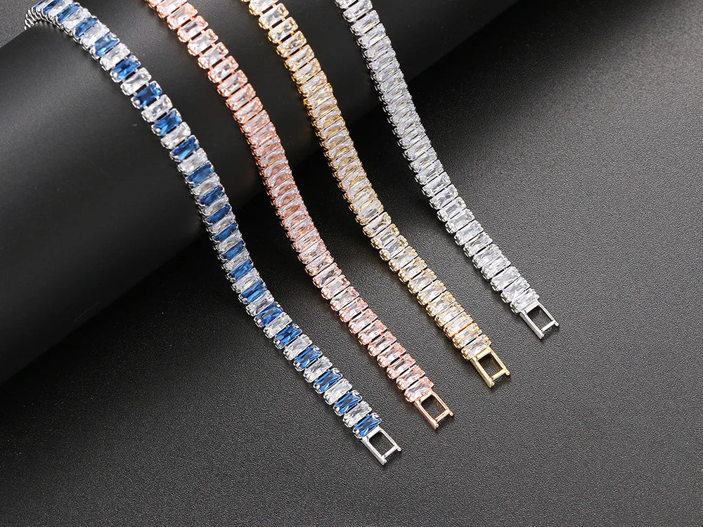 Three diamond bracelets in silver, rose gold, and white gold on a dark surface