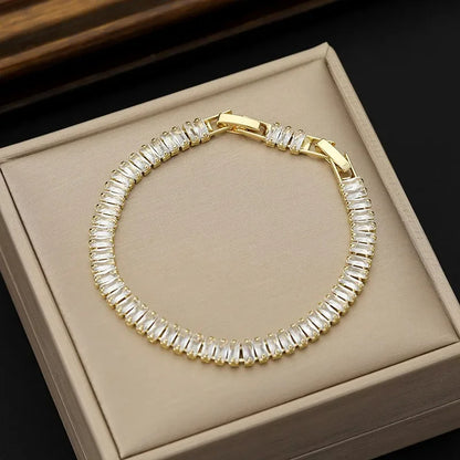 Gold bracelet with clear stones on a beige box