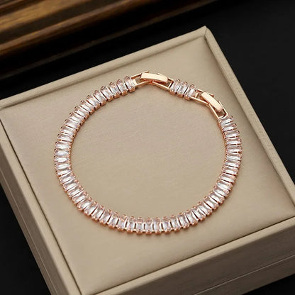 Rose gold bracelet with clear stones on a beige jewelry box